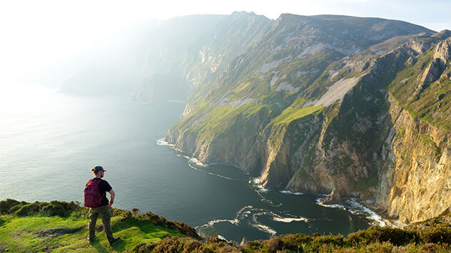 Mensch schaut über Irlands höchste Seeklippen im Südwesten Donegals
